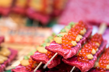 Retail display of skewered wagyu red beef with sea urchin and caviar on skewer sticks in Tsukiji...