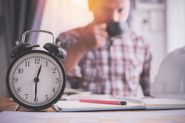alarm clock with businessman drinking coffee, concept of rush hour.