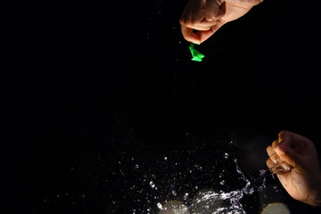 Popping the water balloon on black background