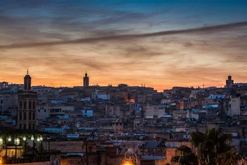 Fotobehang Violet sunset above moroccan city Fes with silhouette of minarets © marketanovakova