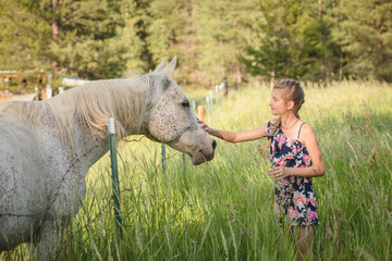 girl petting white horse 