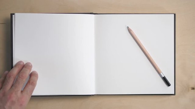 Opening a notebook. Blank pages to insert text and subtitles. The male hand flips over the pages, a pencil that has been thwarted. Cool for the background or the beginning of the movie.