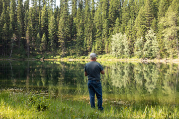 Fototapeta na wymiar man fishing at a lake in the forest 