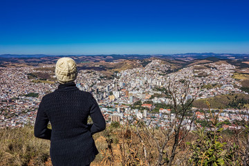 Photo with woman on top of the mountain watching the city Po&ccedil;os de Caldas - Minas Gerais / Brazil - below. 