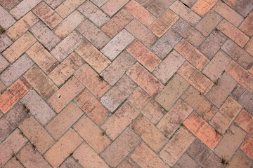 隙間から雑草が生えている煉瓦敷きの地面