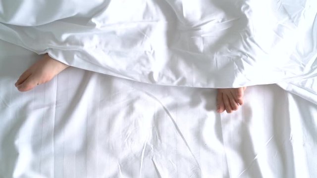 Feets woman on bed in hotel room under blanket comfortable resting people lifestyle.