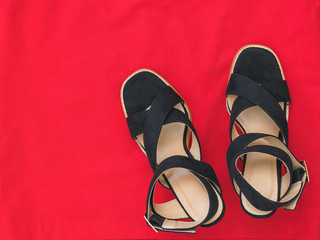 Modern fashionable summer women's shoes on red fabric. Flat lay.