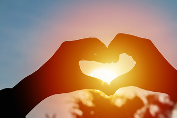 love shape hand silhouette at sunset