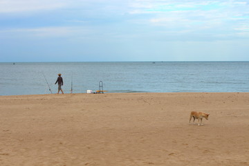 Prachuap Khiri Khan Province, Thailand - June 29, 2019: A man fishing at the beach in Pranburi.