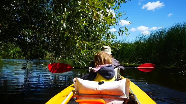 A child in a kayak on the river. Family outdoor activities.