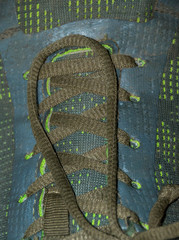 Green laces on a green shoe isolated and up close