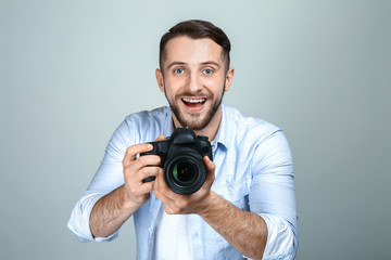 Fototapeta premium Handsome male photographer on light background