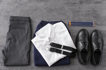 School uniform and stationery on grey background