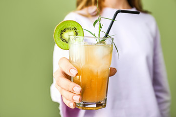 Woman with glass of tasty summer cocktail on color background, closeup