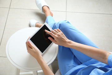 Nurse with tablet computer in clinic
