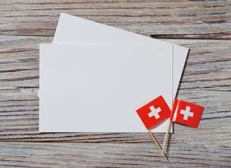independence day Switzerland, August 1. Federal holiday in honor of the founding of the Swiss Confederation. the concept of freedom, Alliance and Union. mini flags with sheets of white paper on wood