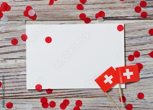 Swiss independence day, August 1. Federal holiday in honor of the founding of the Swiss Confederation. day of the Confederacy. flags and confetti with sheets of white paper on a wooden background