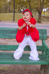 Happy little girl in autumn park. Fashion Kid outdoor.