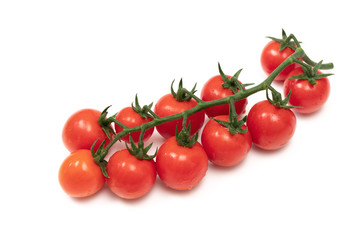 A branch of red cherry tomatoes on a white background. Small and juicy vegetable is rich in vitamins and trace elements. Healthy food. Fresh and organic vegetables. Raw food