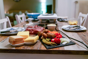 Swiss or Dutch raclette table filled with ingredients for a celebratory evening like Christmas or New Years Eve