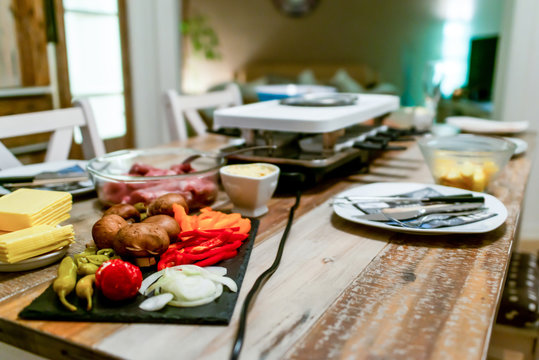 Swiss or Dutch raclette table filled with ingredients for a celebratory evening like Christmas or New Years Eve