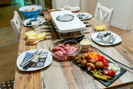 Swiss or Dutch raclette table filled with ingredients for a celebratory evening like Christmas or New Years Eve