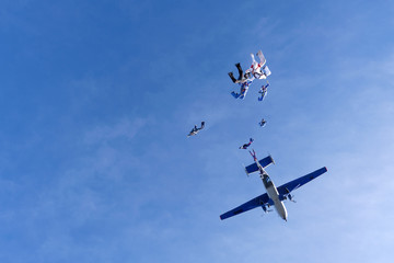 Skydivers are jumping out of a plane.