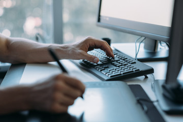 Web graphic design. Cropped shot of male artist drawing with stylus on digital tablet. Blur screen background. Copy space.