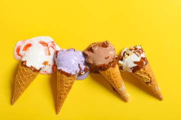 top view multiple flavor ice cream cones in a melting process on yellow background