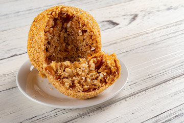 top view section of traditional Chinese fried sesame ball on white wood table