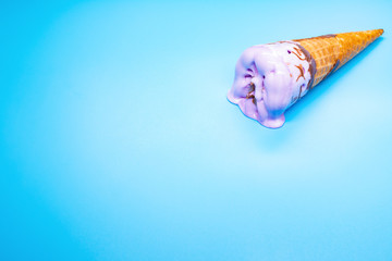 side view lilac ice cream cone starts melting on blue background