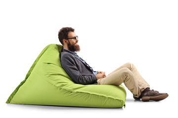 Bearded man sitting on a modern green bean bag chair