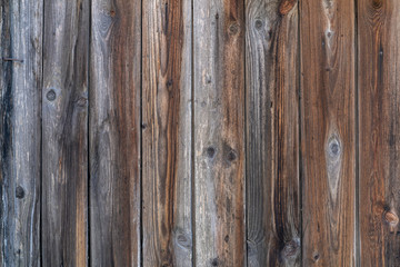 old wooden fence. Faded wooden planks with corrosion. Peeled wooden door of several boards. Old natural wooden board without paint.
