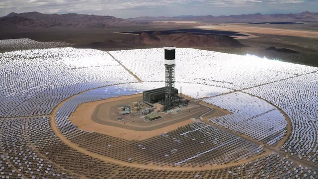 Breath taken panoramic view at circles of solar panels around high tower in the middle. Heliostat at the Nevada desert at daylight. Aerial 4K