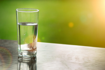 Glass of water purified fresh drink water on table outdoors