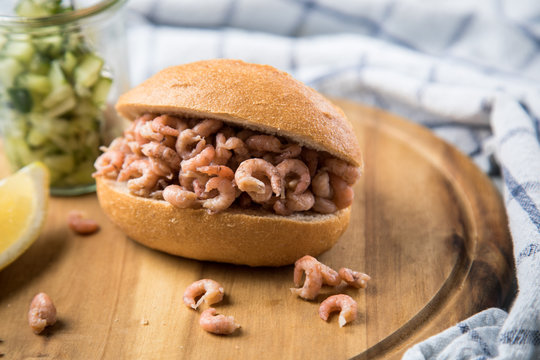 Norddeutsche Friesische Nordseekrabben in Glas Schale mit Br&ouml;tchen, Gurkensalat und Zitronen auf Holz Brett