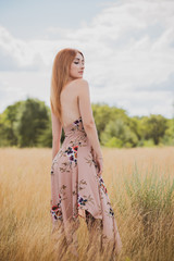 Obraz premium Freedom concept, elegant woman in long beige romantic dress at the field 