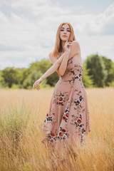 Obraz premium Freedom concept, elegant woman in long beige romantic dress at the field 
