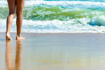 Feet barefoot girl near the water's edge by the sea