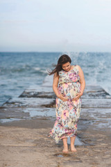 Fototapeta na wymiar pregnant woman in dress looking at belly