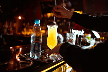 Expert barman is making cocktail at night club