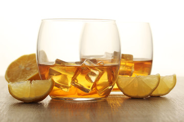 Two glasses with whiskey with ice cubes