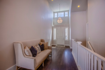 Home interior with a sofa in front of the stairs that leads to the lower floor