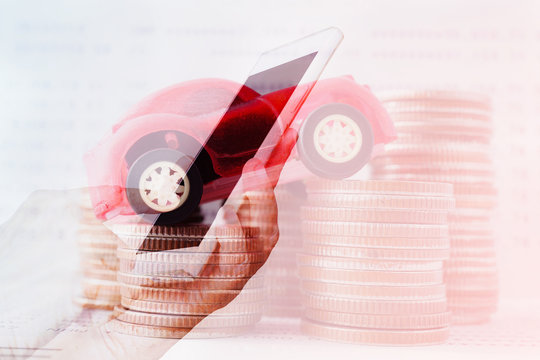 double exposure of hand with mobile and car on stack of coins for business and finance background