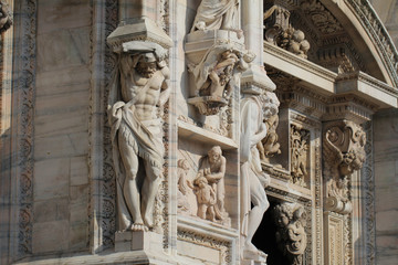 The marvellous statue in front of Duomo milano, The mistery art on external building of Famous white Architectural cathedral church under blue sky at Milan, The largest church in Italy, travel destina