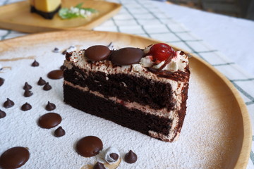 Close up a half piece of chocolate cake in a wooden dish on the table.