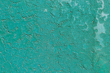 Concrete background in cracks of green color
