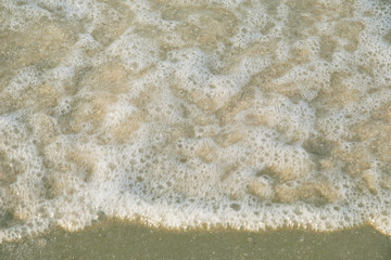 Fototapeta na wymiar Wave of water splash on the sea beach