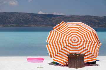 the colorful umbrella by the clean and clear sea and people lying on the sand at the beach for holiday and tourism agent concept.