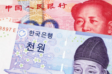 A blue two thousand won note from South Korea close up in macro with a red, one hundred yuan note...